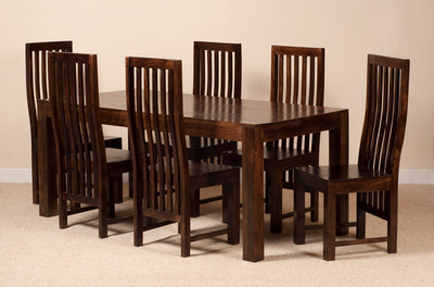 A 7-piece dark brown wooden dining table set with six matching slatted-back chairs, shown against a plain beige wall and carpeted floor.