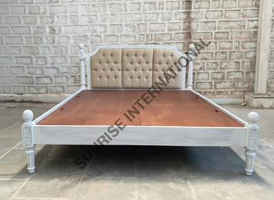 Wooden bed with upholstered tufted headboard and handcrafted carved details