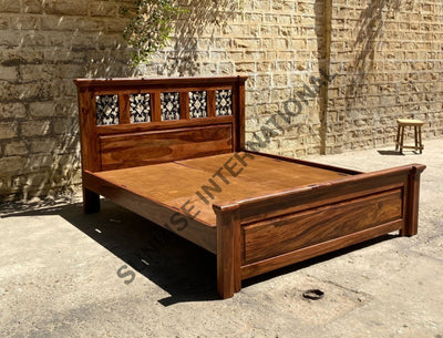 Solid Sheesham wood bed with decorative jali headboard, angled frame view