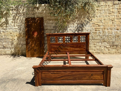Sheesham wooden bed showing mattress support frame and artistic jali headboard