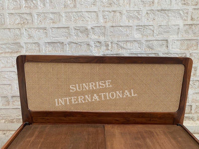 Rattan cane headboard on solid Sheesham wood bed, close-up view