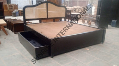 Sheesham wood bed with side storage drawers and rattan cane headboard, angled view