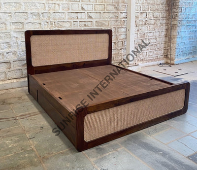 Sheesham wood rattan cane storage bed with drawers closed, angled view