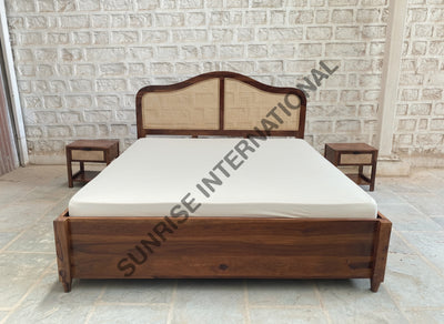 Wooden bed with rattan cane headboard and box storage, front view