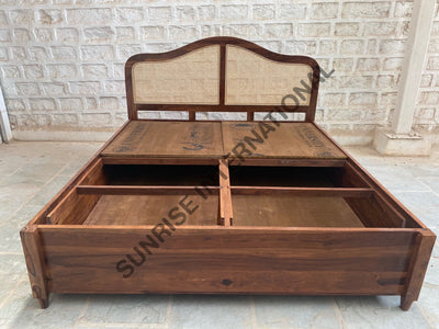Wooden bed showing open top box storage compartments
