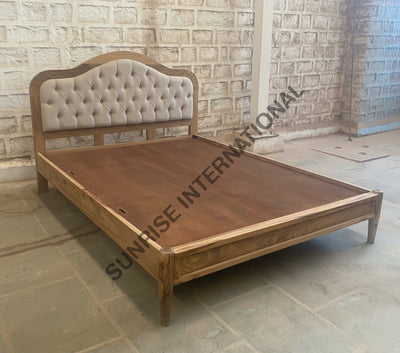 Solid wood bed with upholstered tufted headboard, angled view