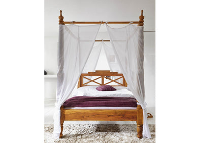 Mango wood four poster bed with carved posts and geometric headboard, front view