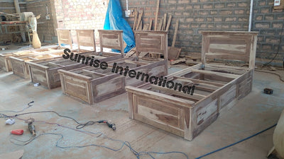 Unfinished wooden single bed frames with storage compartments in workshop